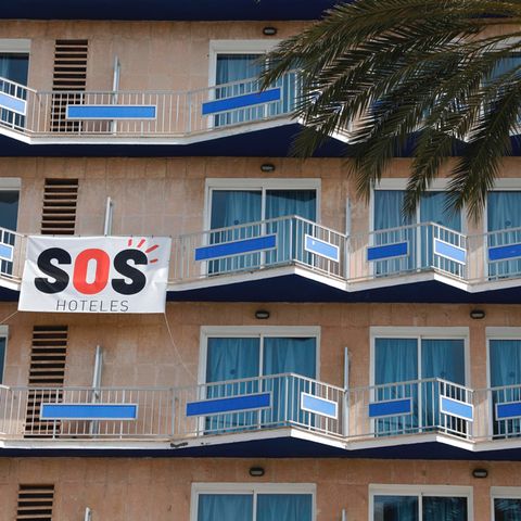 Ein Transparent mit der Aufschrift "SOS Hoteles" hängt an der Fassade eines Hotels auf Mallorca.