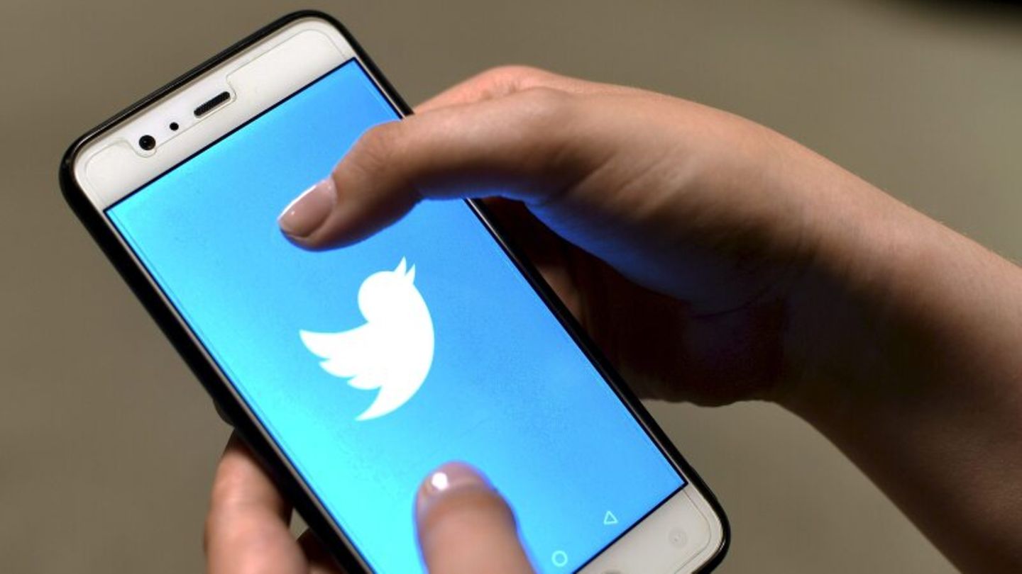 Hand hält Smartphone mit Twitter-Logo