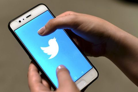Hand hält Smartphone mit Twitter-Logo