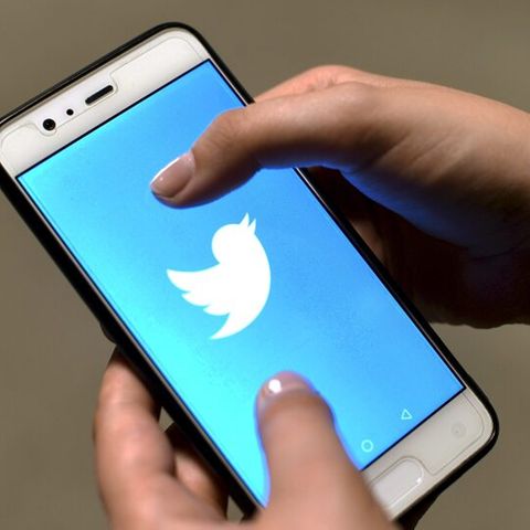 Hand hält Smartphone mit Twitter-Logo