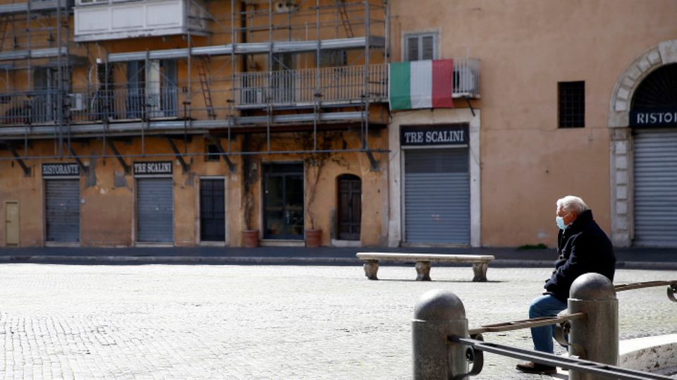 Ein Mann sitzt auf dem fast menschenleeren Navona-Platz in Rom