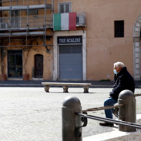 Ein Mann sitzt auf dem fast menschenleeren Navona-Platz in Rom