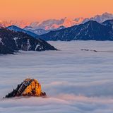 Dieses Bild entstand an einem klaren Novemberabend auf der Hochplatte. Es ragt gerade noch der Leonhardstein aus dem Hochnebel hervor, dahinter glühen die zackigen Gipfel des Wilden Kaisers und der Loferer Steinberge.