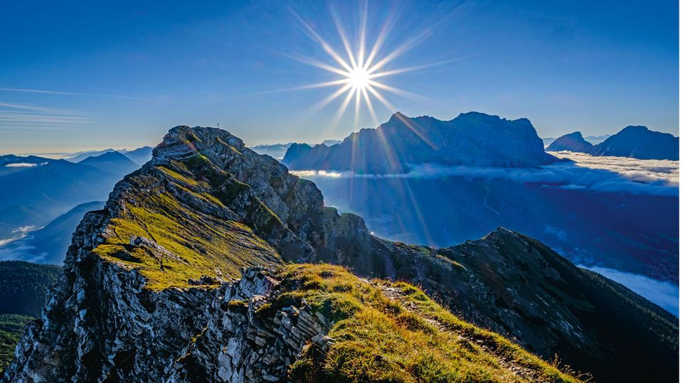 Blick von der Upsspitze auf den Daniel, den höchsten Berg der Ammergauer Alpen. Dahinter die Silhouette des Zugspitzmassivs. Eines der Motive aus dem neuen Bildband "Naturwunder Bayerische Alpen" von Bernd Römmelt.