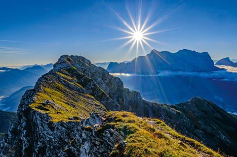 Blick von der Upsspitze auf den Daniel, den höchsten Berg der Ammergauer Alpen. Dahinter die Silhouette des Zugspitzmassivs. Eines der Motive aus dem neuen Bildband "Naturwunder Bayerische Alpen" von Bernd Römmelt.