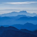 Ein klarer Sommermorgen auf dem Watzmann Hocheck. In der Ferne leuchtet blau aus dem morgendlichen Dunst der Hohe Dachstein. Knesebeck