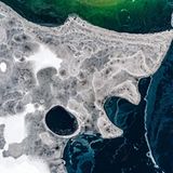 Ein Narr aus Eis oben die Narrenkappe, unten die Nase und der weit geöffnete Mund. Entdeckt auf dem Plansee in den Ammergauer Alpen.