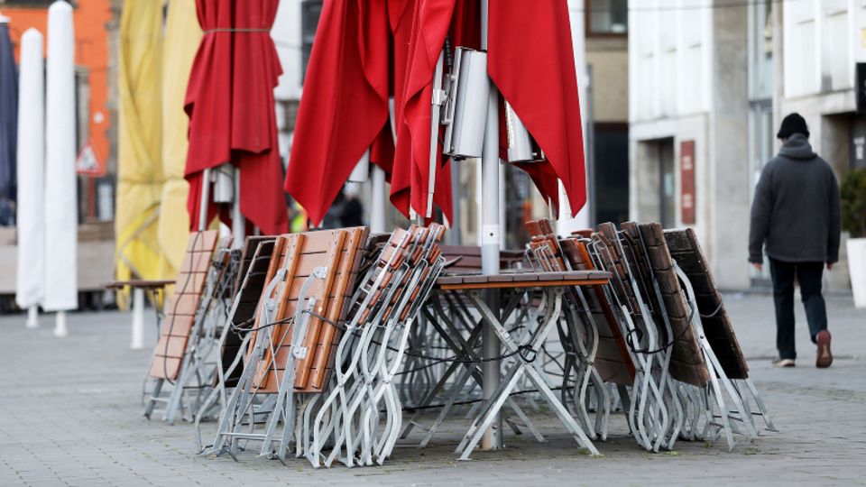 Tische und Stühle eines Restaurants sind eingeklappt und abgesperrt.