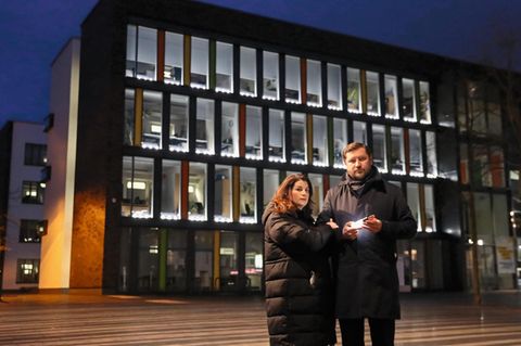 Tim Kurzbach (SPD) mit seiner Frau vor dem Rathaus. In Kurzbachs Hand und in den Fenstern leuchten Lichter zum  Gedenken an die Corona-Toten