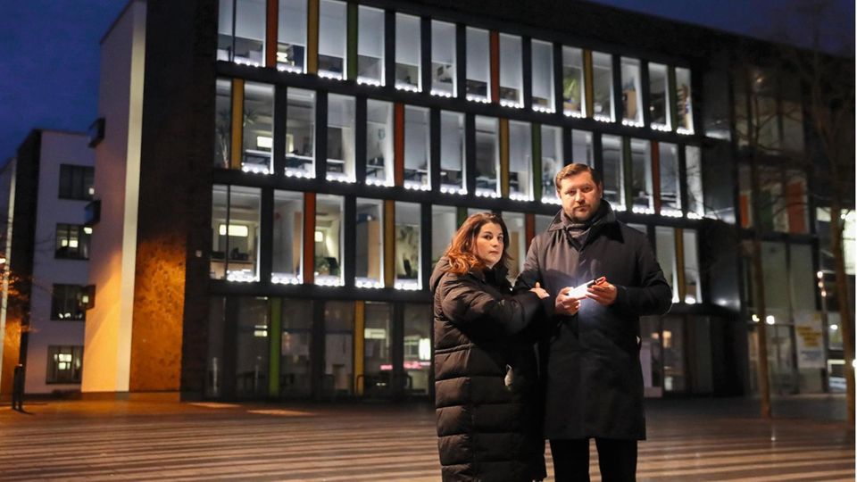 Tim Kurzbach (SPD) mit seiner Frau vor dem Rathaus. In Kurzbachs Hand und in den Fenstern leuchten Lichter zum  Gedenken an die Corona-Toten