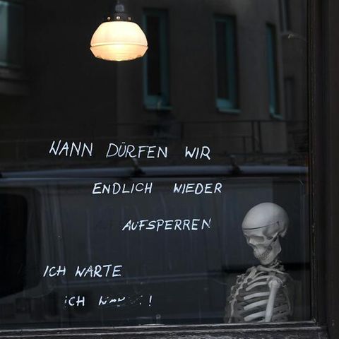 Ein Skelett sitzt in einem Café am Fenster