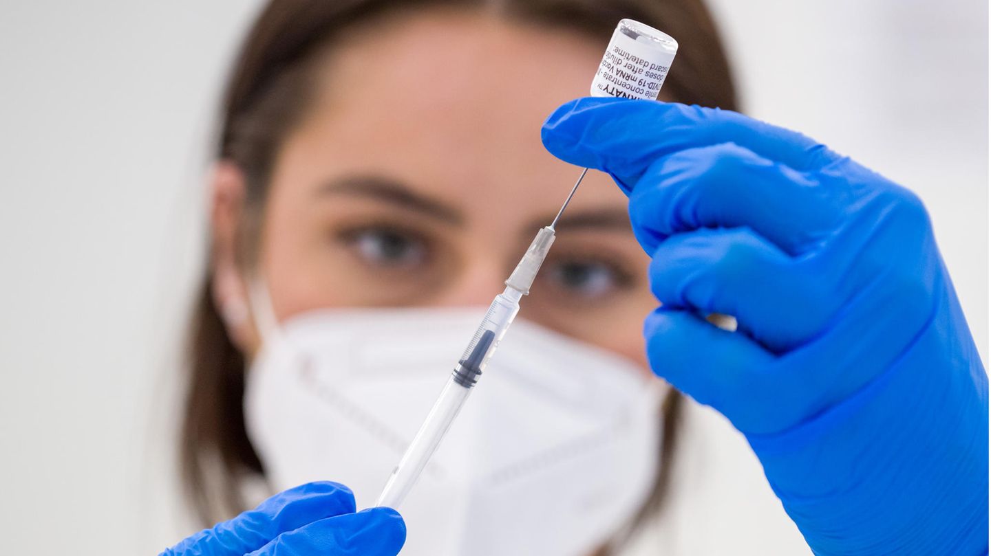 Eine Mitarbeiterin bereitet eine Impfspritze vor
