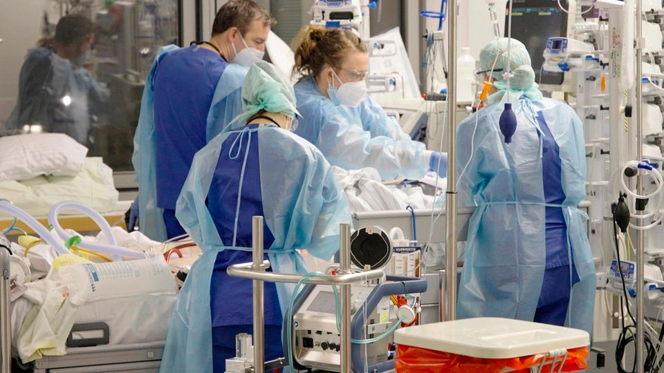 Ärztinnen, Ärzte und Pflegende arbeiten auf der Corona-Intensivstation der Charité am Bett einer jungen Patientin