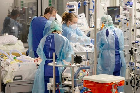 Ärztinnen, Ärzte und Pflegende arbeiten auf der Corona-Intensivstation der Charité am Bett einer jungen Patientin