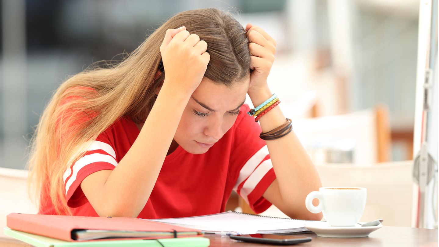 Studentin beugt sich über ihre Notizen