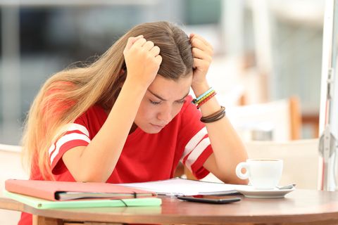 Studentin beugt sich über ihre Notizen