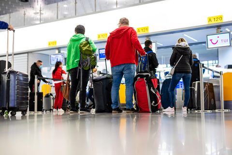 Fluggäste mit dem Reiseziel Mallorca stehen im Flughafen Hannover-Langenhagen am Check-in