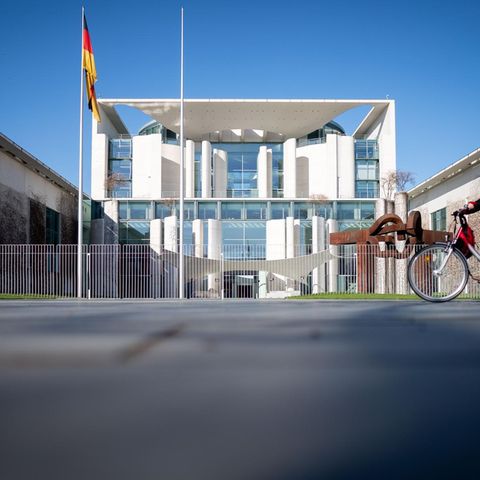 Eine Radfahrerin fährt am Morgen am Bundeskanzleramt vorbei