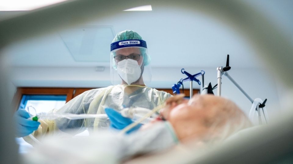  Ein Intensivpfleger arbeitet in Schutzausrüstung auf der Intensivstation des Krankenhauses Bethel an einem Corona-Patienten