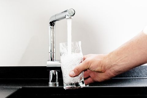 Zum Weltwassertag: Trinkwasser fließt aus einem Wasserhahn in ein Glas