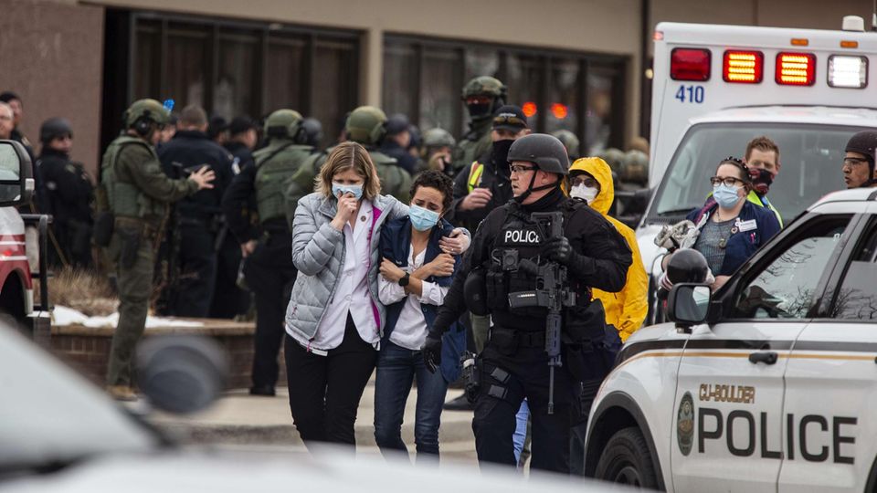 Menschen werden vom Tatort in Boulder, Colorado weggebracht