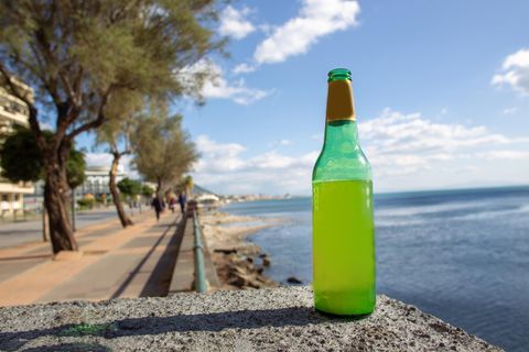 Ein Flasche Bier steht an einem Gewässer