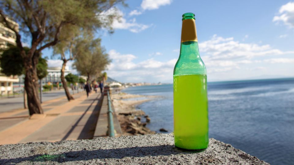 Ein Flasche Bier steht an einem Gewässer