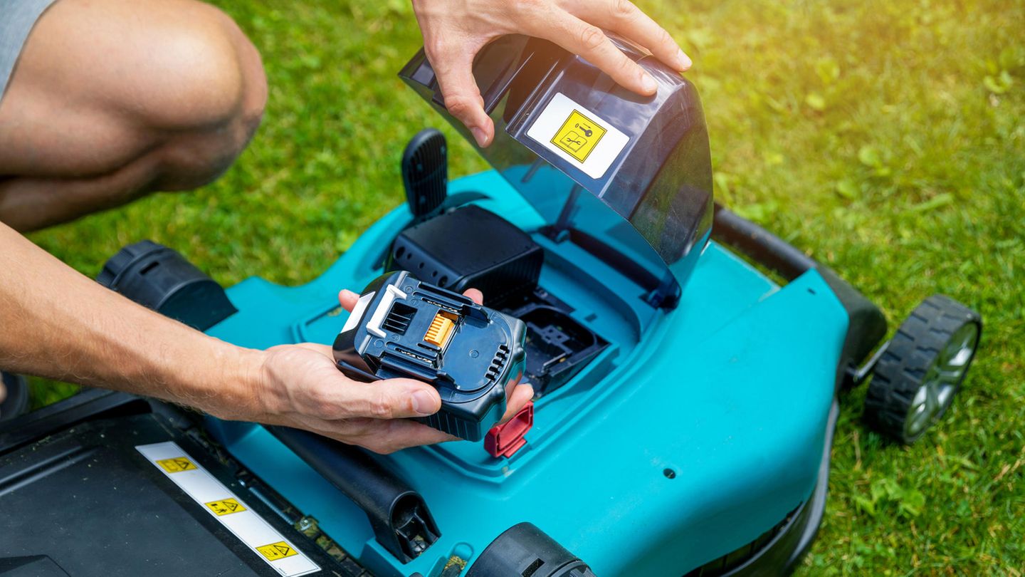 Mower at Stiftung Warentest: man is holding the battery from the mower in the Hand