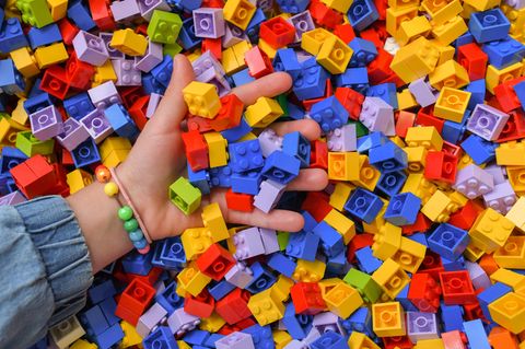 Hand greift in große Menge Legosteine