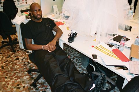 Virgil Abloh sitzt an seinem Schreibtisch, auf dem ein Model im Brautkleid steht