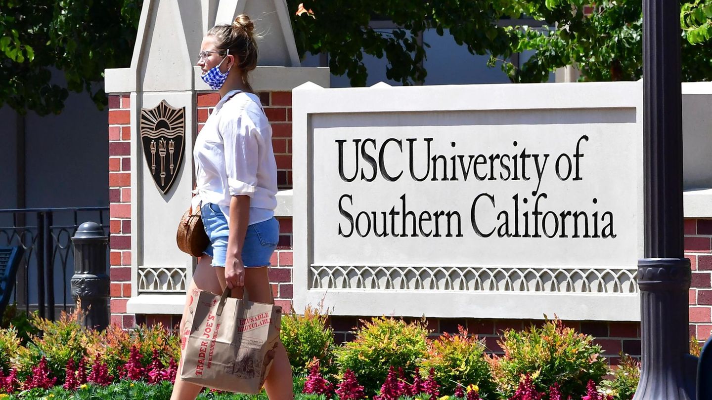 Eine junge Frau vor einem Schild mit der Aufschrift "University of California"