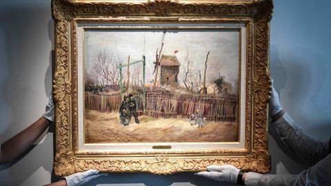 Mitarbeiter des Auktionshauses Sotheby's halten mit behandschuhten Händen das Gemälde "Scène de rue à Montmartre" 