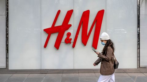 Eine Frau geht am Flagshipstore der Bekleidungsmarke H&M in einer Einkaufszone in Peking vorbei
