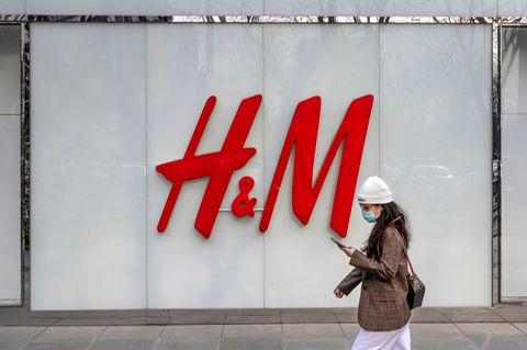 Eine Frau geht am Flagshipstore der Bekleidungsmarke H&M in einer Einkaufszone in Peking vorbei