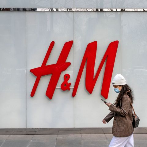 Eine Frau geht am Flagshipstore der Bekleidungsmarke H&M in einer Einkaufszone in Peking vorbei