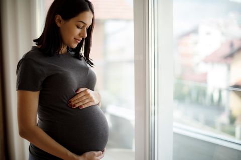 Schwangere Frau hält ihren Bauch