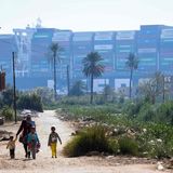 Wie ein Fremdkörper wirkt die festsitzende Wand aus Containern für die Menschen, die an den Ufern des Suezkanals leben.