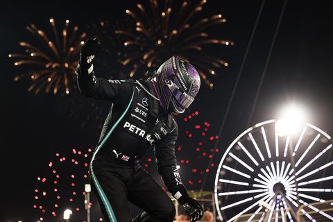 Lewis Hamilton springt unmittelbar nach dem Rennen aus seinem Auto, während ein Feuerwerk den Himmel über Bahrain erhellt