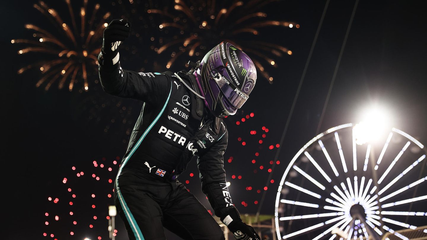 Lewis Hamilton springt unmittelbar nach dem Rennen aus seinem Auto, während ein Feuerwerk den Himmel über Bahrain erhellt