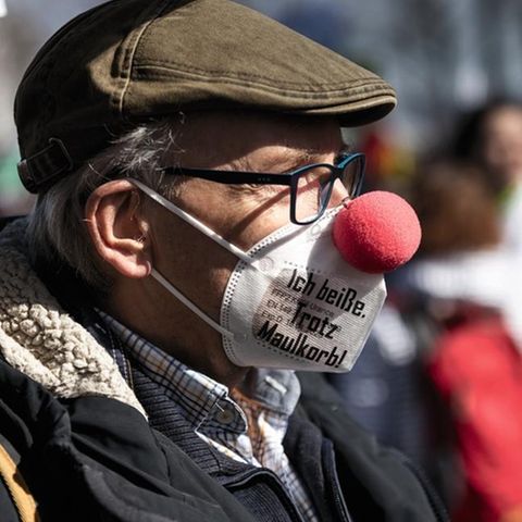 Jemand, der sich für einschlägig informiert halten mag: Querdenker- Clown bei einer Demonstration  in Kassel
