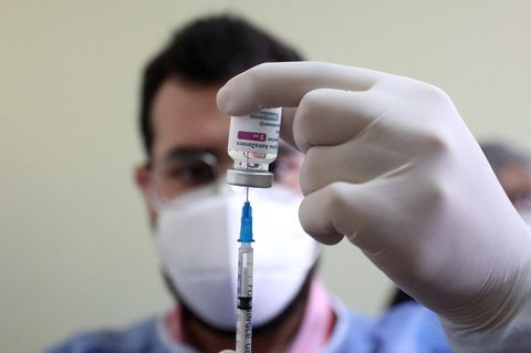 Arzt zieht Impfspritze mit Astrazeneca-Stoff auf