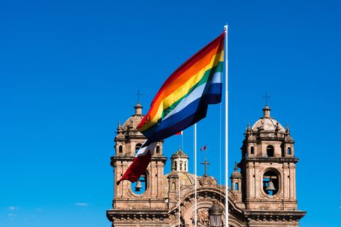 Regenbogenflagge weht vor Kirchturm