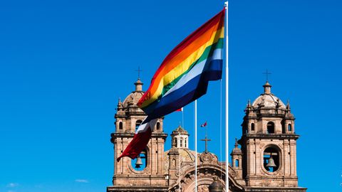 Regenbogenflagge weht vor Kirchturm