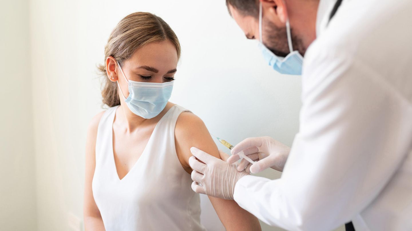 Eine Frau lässt sich von einem Arzt impfen