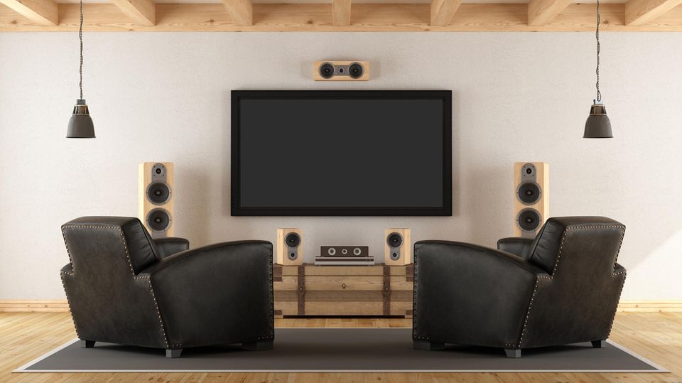 Lautsprecher für Fernseher: Lautsprecher aus Holz umringen den TV.