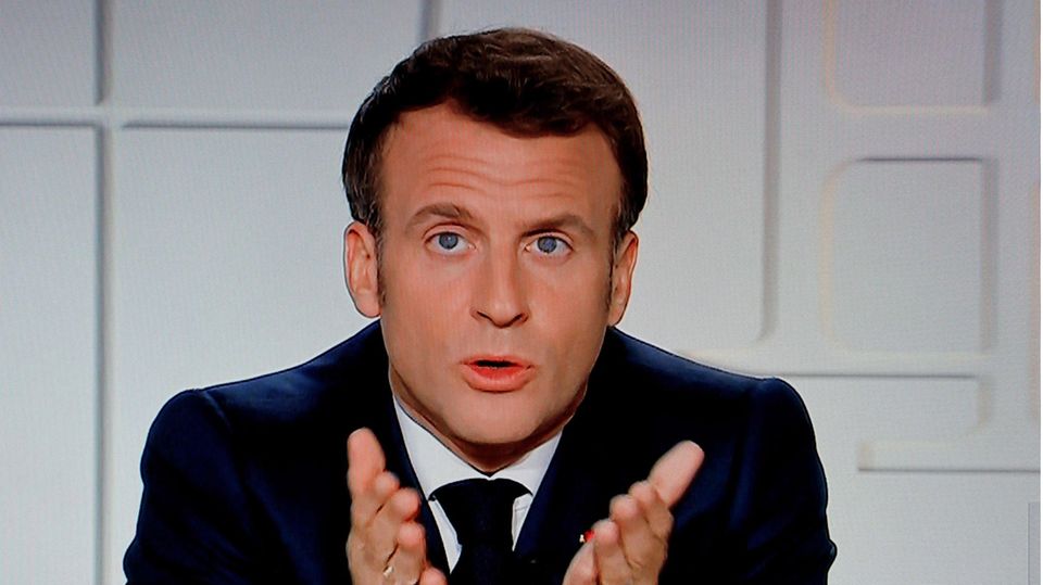 Emmanuel Macron Frankreichs Präsident Macron sitzt in einem TV-Studio vor weißem Hintergrund und zeigt mit beiden Händen auf die TV-Zuschauer