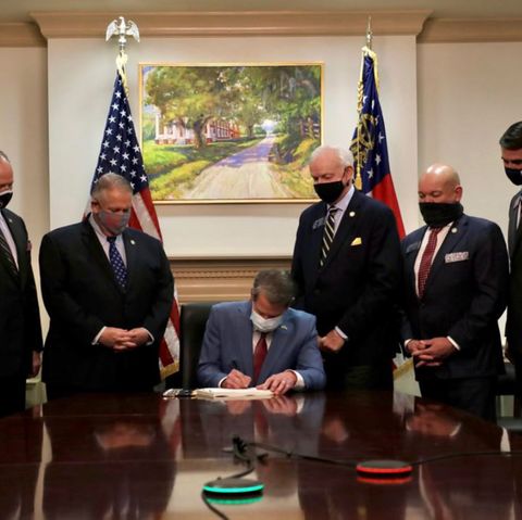 Georgias Gouverneur Brian Kemp unterzeichnet neues Wahlgesetz unter Plantagen-Gemälde