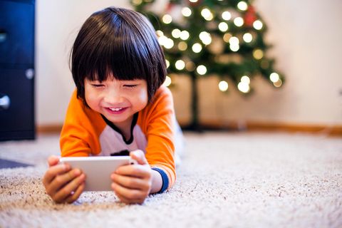 Junge spielt auf einem Smartphone.