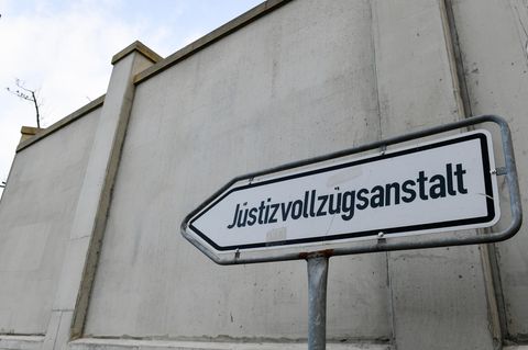 Ein Schild der Justizvollzugsanstalt vor einer Mauer des Gebäudes in Dresden