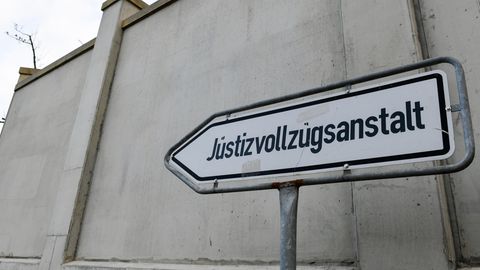 Ein Schild der Justizvollzugsanstalt vor einer Mauer des Gebäudes in Dresden
